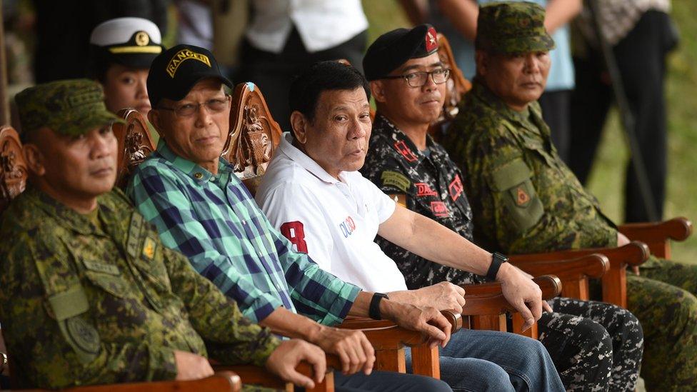 Philippine President Rodrigo Duterte (in white) watches a simulation of a hostage rescue in San Miguel town, north of Manila, 15 September 2016