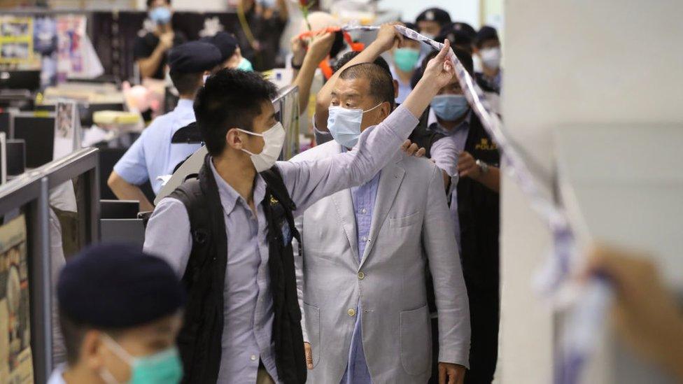 Police lead Hong Kong media tycoon Jimmy Lai through his Apple Daily headquarters after a sweeping raid and arrests on August 10 2020