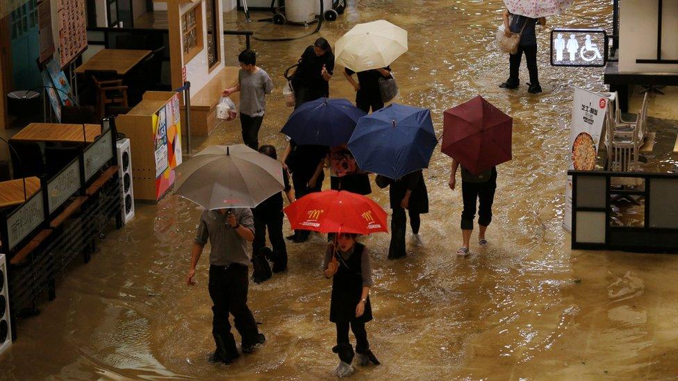 People wade through seawater inside a mall in Heng Fa Chuen, a residental district near the waterfront in Hong Kong, China September 16, 2018.