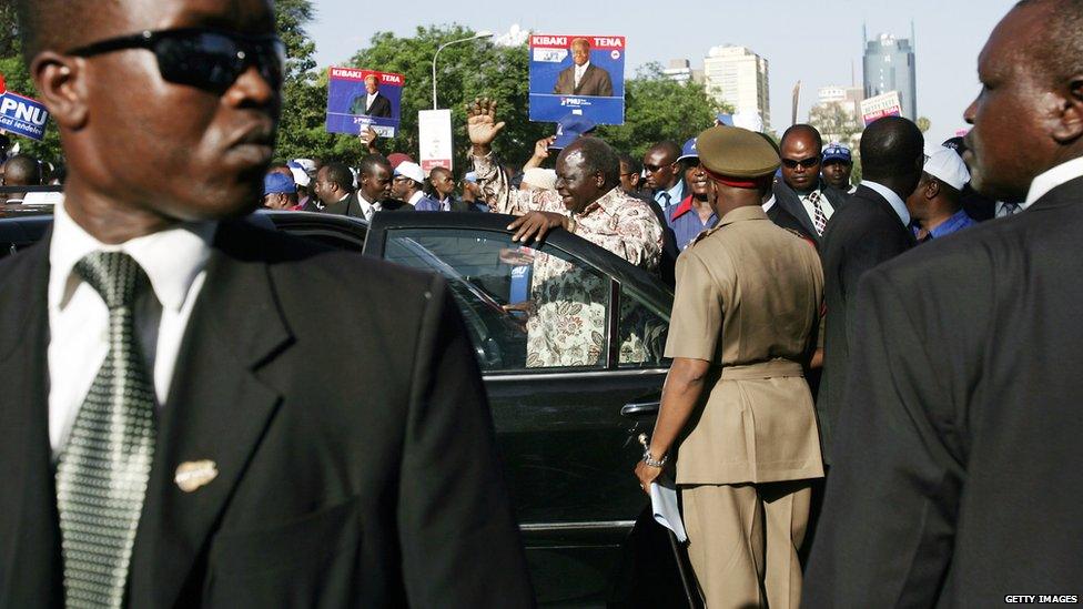 Kenyan President and presidential candidate Mwai Kibaki (C) waves to supporters before getting into his car surrounded with body guards after a rally in downtown Nairobi, 24 December 2007