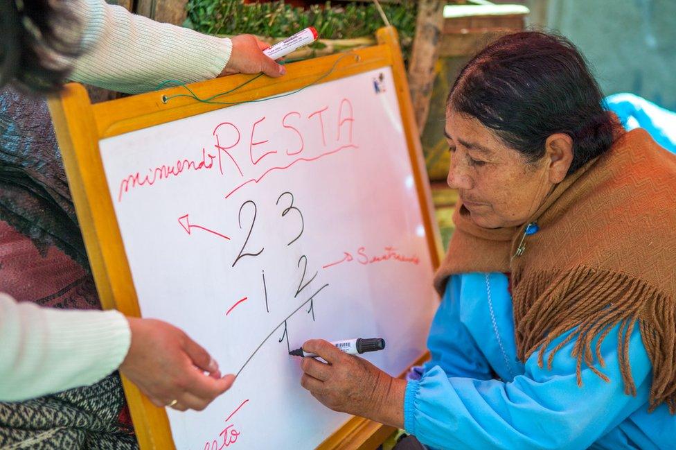 A student writes on Ms Guizman's whiteboard