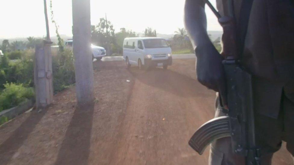 cars driving and an armed man riding a vehicle