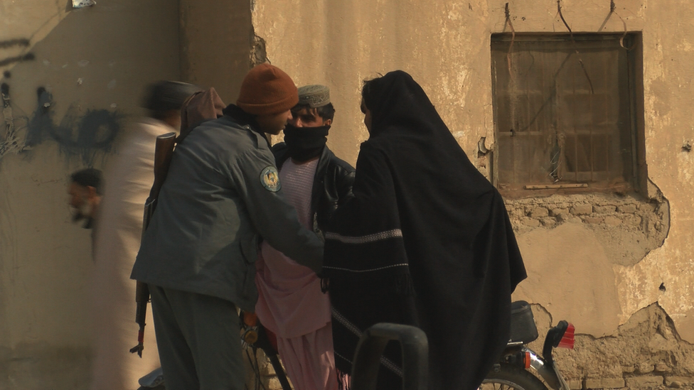 Officers conduct a search at a police post just 8 kilometres from the nearest Taliban checkpoint outside Kandahar