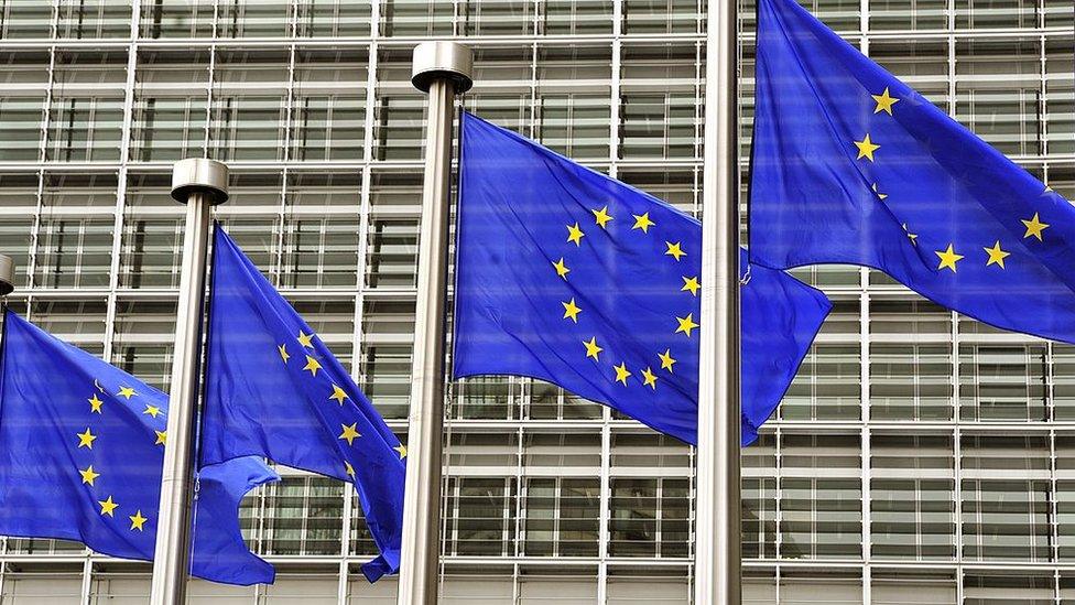 EU flags fly at the entrance to the EU Commission in Brussels