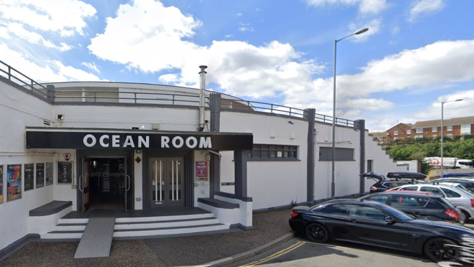 Image of a white building with Ocean Room written on the top of the entrance