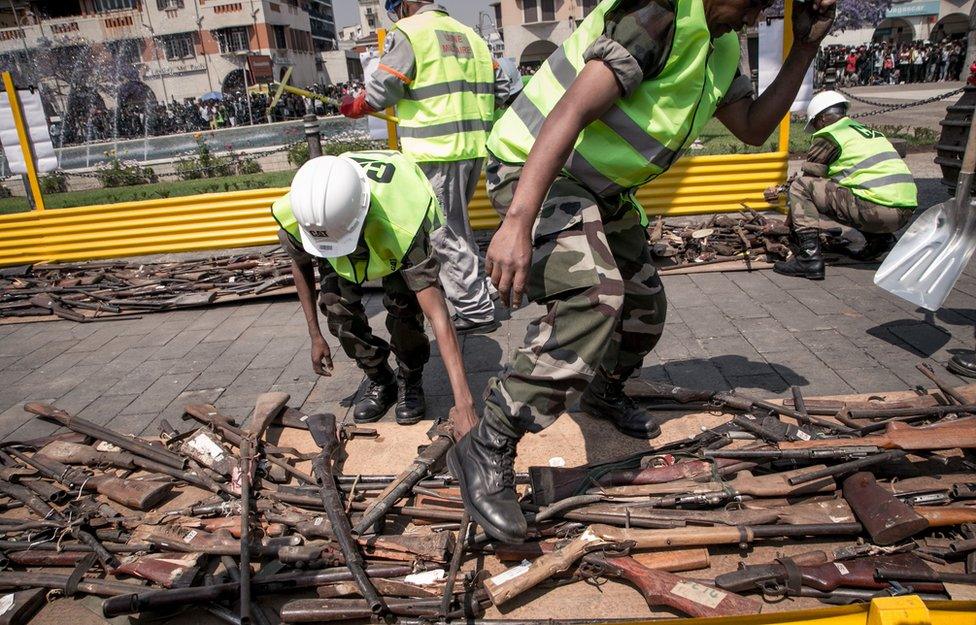 Malagasy army personnel inspect firearms that are being destroyed by a bulldozer during a ceremony organised by the government to disable approximately 800 weapons, on October 16, 2018, on Antananarivo"s May 13th Square. - These weapons are mainly handmade hunting rifles and assault rifles from abroad.