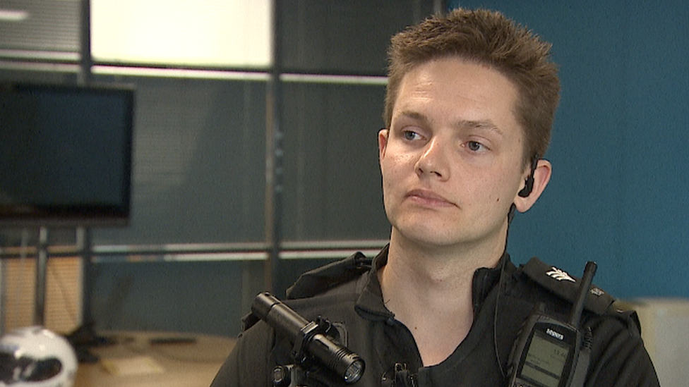 Police officer sits at a table in an incident room