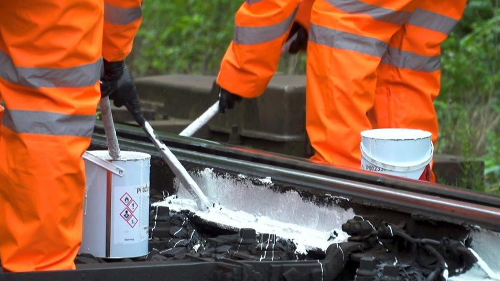 Rail workers painting the rails white