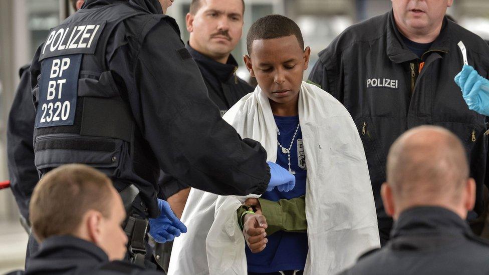 A young boy covered is registered by German police at the train station in Rosenheim, Germany in September 2015