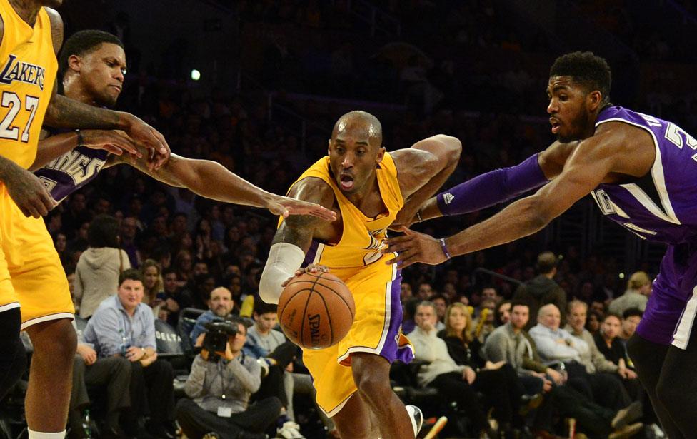 Kobe Bryant tries to get by Sacramento Kings forward Jason Thompson and teammate Rudy Gay during their NBA game in Los Angeles, California, 2014.