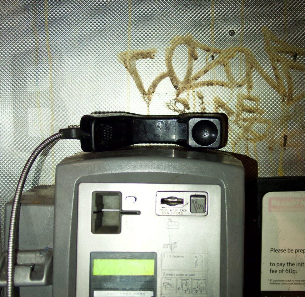 An image of a phone receiver in a public phone booth