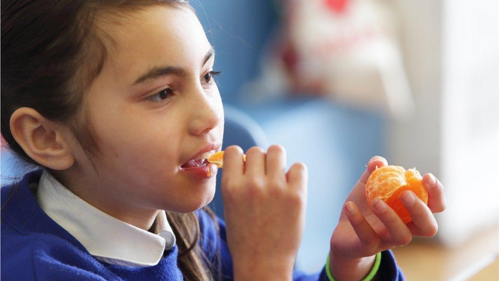 Schoolgirl eating fruit