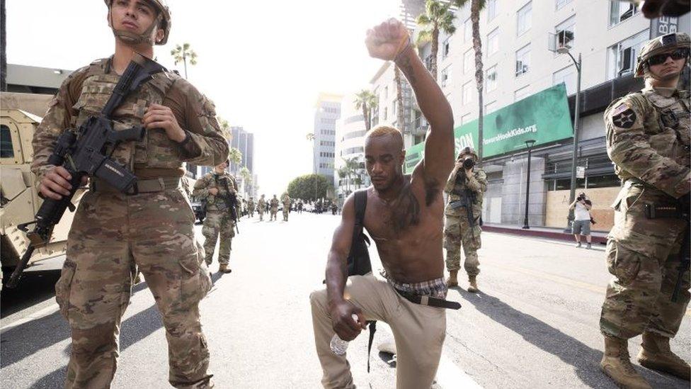 A demonstrator kneels during a march in response to George Floyd's death on June 2, 2020 in Los Angeles, California