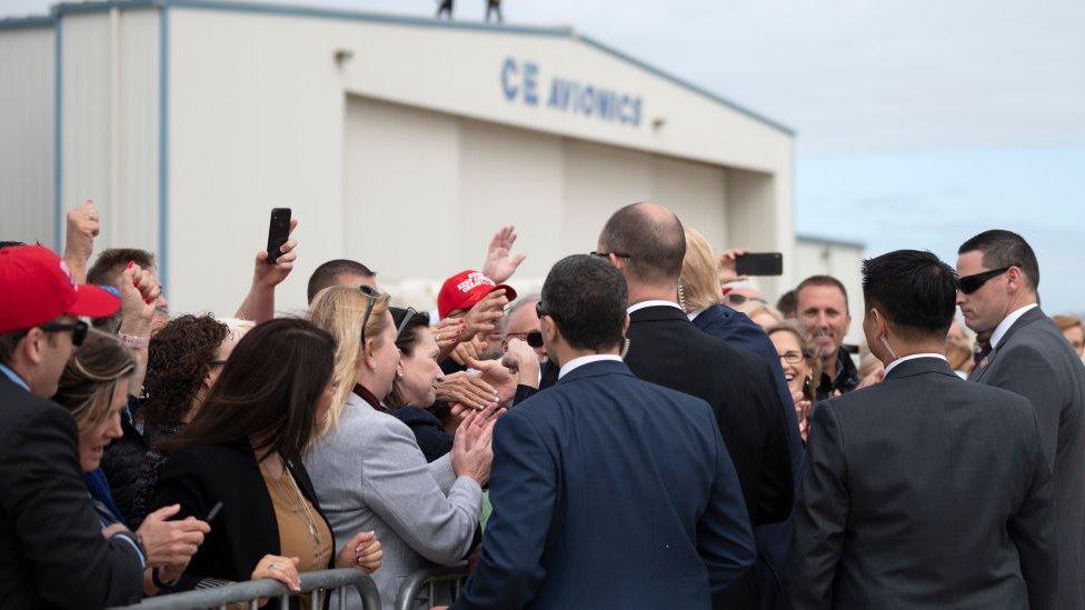 President Donald Trump shakes hands with supporters as he arrives in Orlando, Florida on 9 March