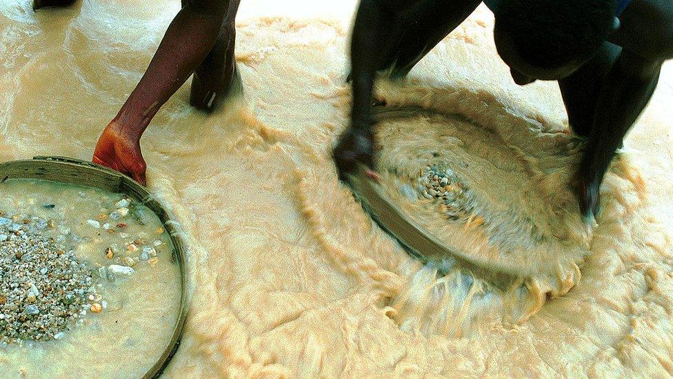 Workers pan for diamonds in a government controlled diamond mine