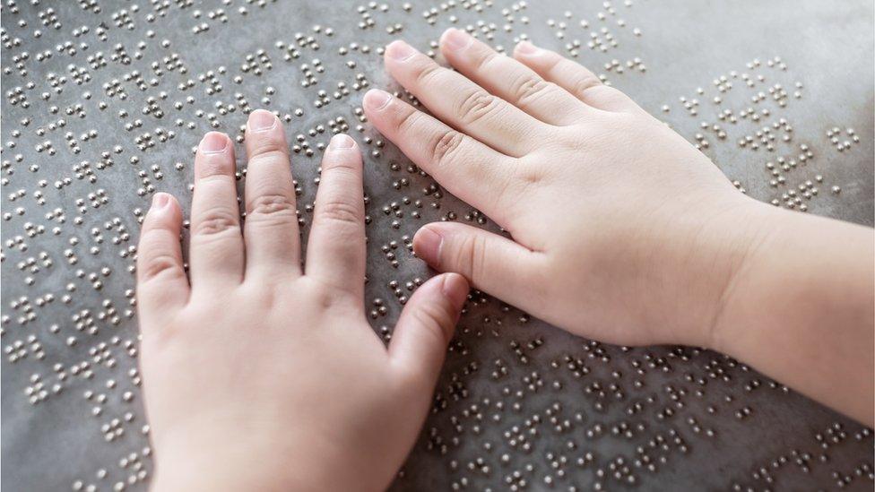 a child's hands as they read brail