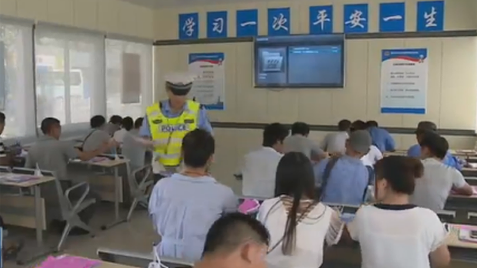 A view of a police officer inside the classroom with people sitting at desks