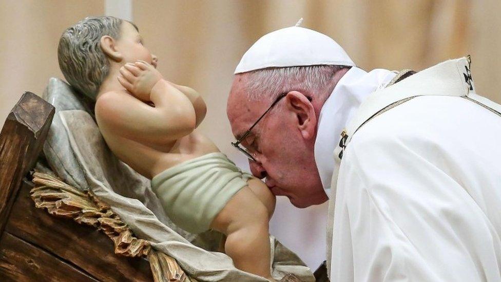 Pope Francis kisses a baby Jesus statue as he leads the midnight Christmas Mass in Saint Peters Basilica at the Vatican (24 December 2015)