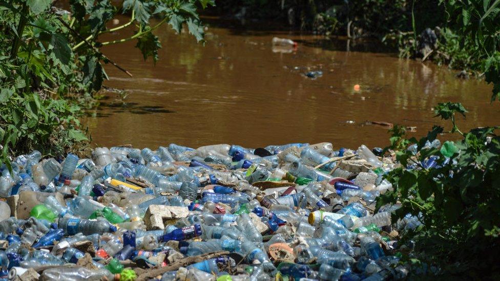 lots of plastic rubbish gathered together on a river