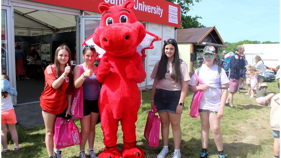 Merched gyda masgot draig goch