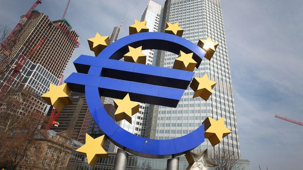 The euro logo is seen in front of the European Central Bank