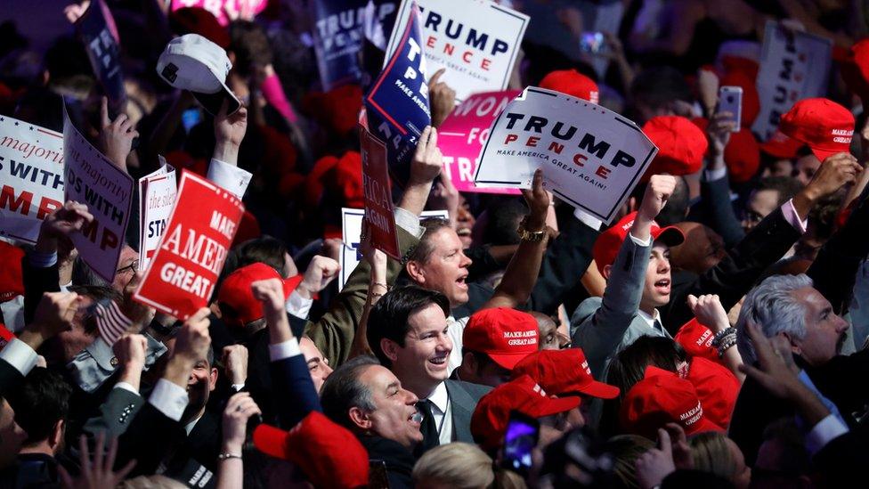 Trump supporters hold up signs