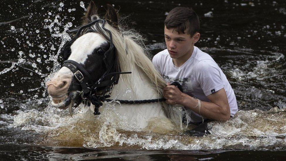 A boy rides his horse in the River Eden during the annual Appleby Horse Fair