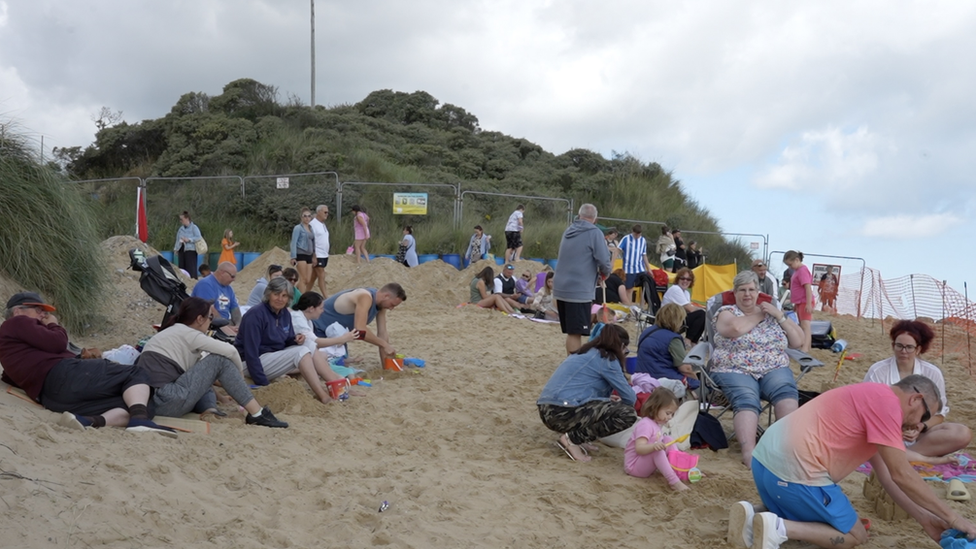 People on just a section of Hemsby beach while where the part that crumbled into the sea is cordoned off