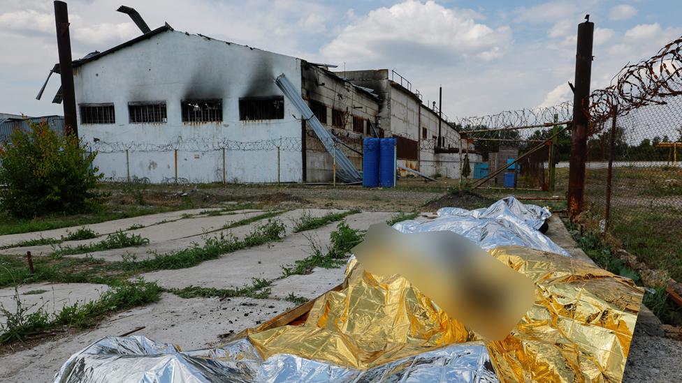 Bodies of detainees lie covered following the shelling at a pre-trial detention centre in the course of Ukraine-Russia conflict, in the settlement of Olenivka in the Donetsk Region, Ukraine July 29, 2022