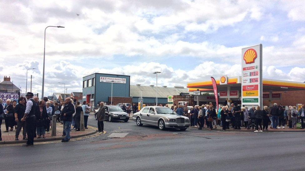 Mourners standing on a main street