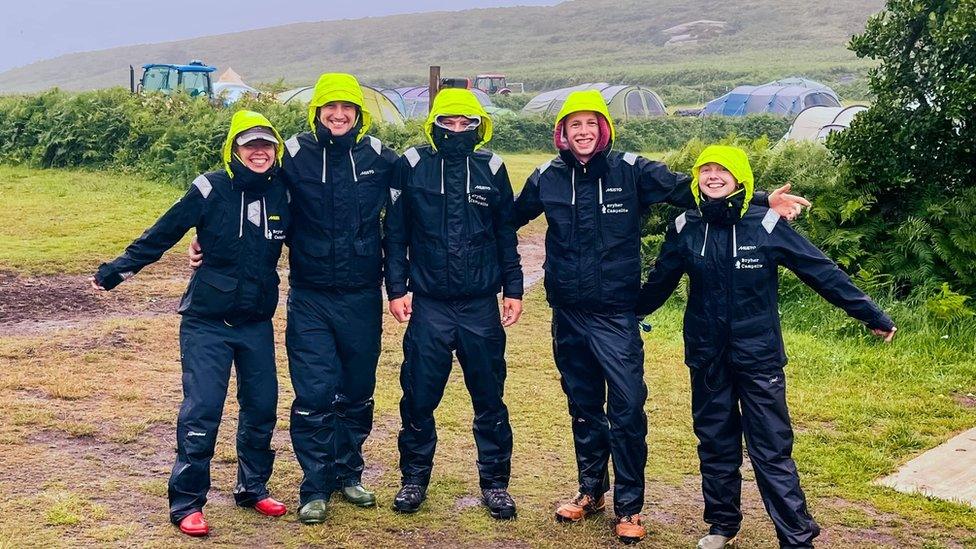 Campsite workers at Bryher campsite stand together in rain