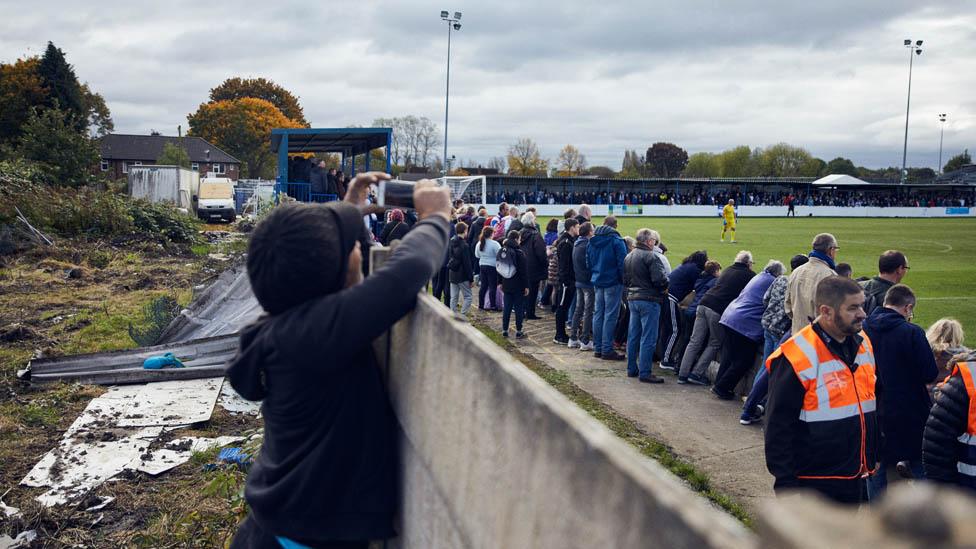 Boy taking a photo at Bury FC