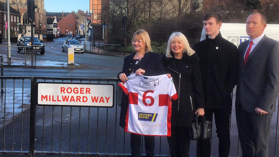 People stood by road sign