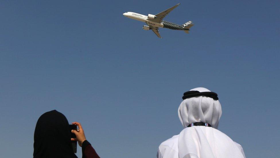 An Emirati couple watch the new Airbus A350 during a flight display at the Dubai Airshow