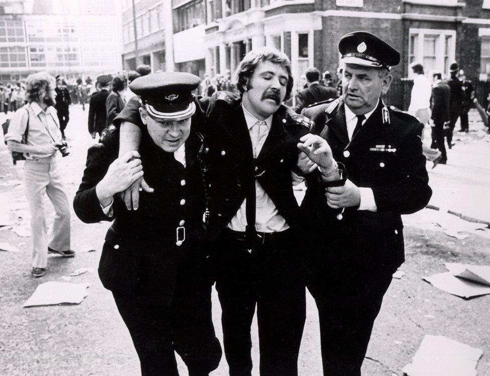 An injured man is helped by volunteers