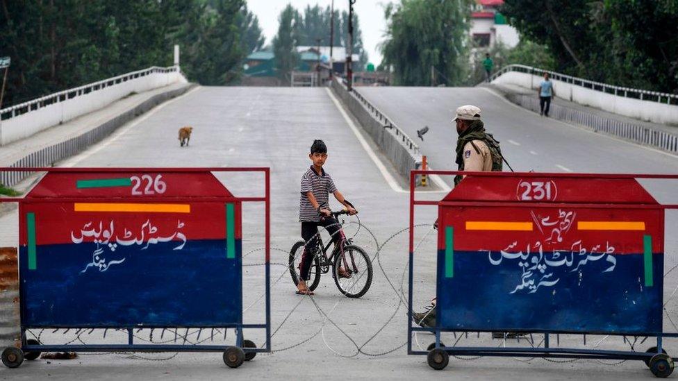 Boy-on-bike-shown-on-deserted-street-in-Srinagar-in-Kashmir.