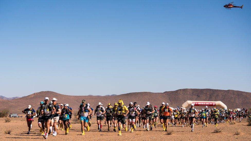 The start of the Marathon des Sables with a helicopter hanging overhead