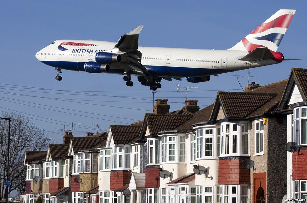 A British Airways 747 aircraft flies over rooftops as it comes into land at Heathrow airport