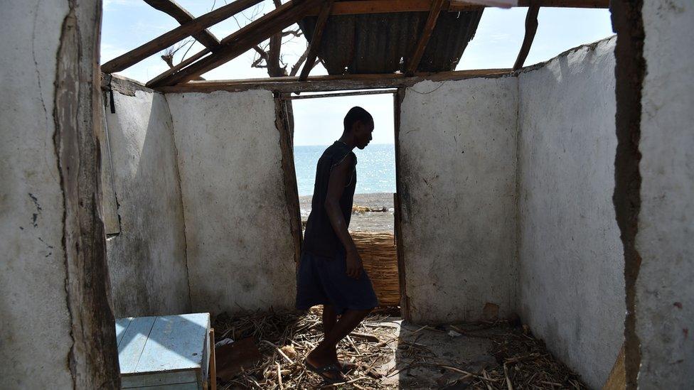 A man stands in his ruined house in Haiti after Hurricane Matthew