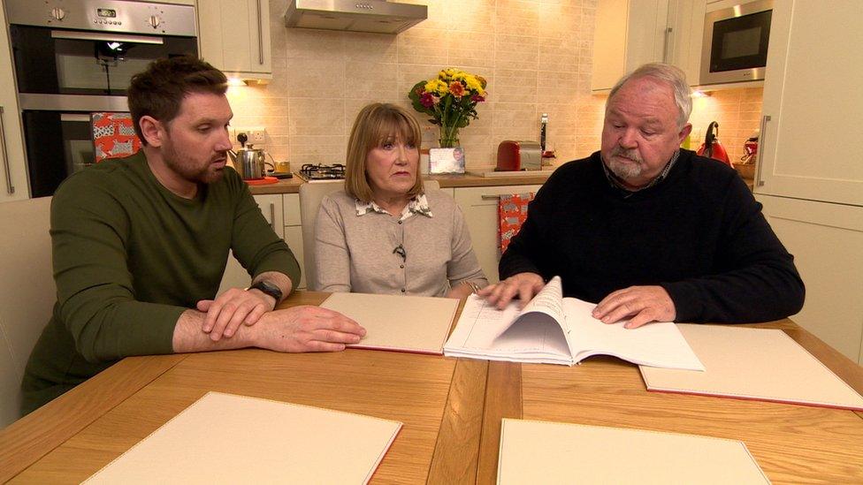 Ross, Charles and Elma Hamilton sitting round kitchen table looking at inquest papers