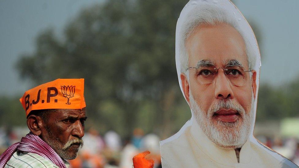 Supporters of India's Bharatiya Janata Party (BJP) listen to BJP Leader and Indian Prime Minister Narendra Modi as he speaks during a state assembly election rally in the village of Andawa on the outskirts of Allahabad on February 20, 2017.