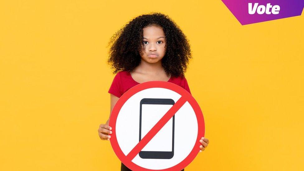 girl holding ban mobile phone sign