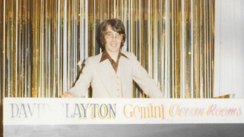 David Clayton at record decks in front of sign saying David Clayton Gemini Ocean Rooms