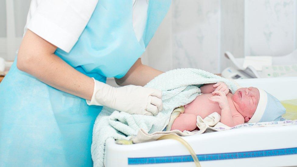 Newborn baby being weighed