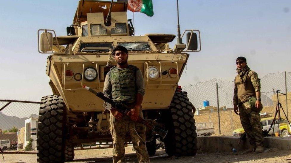 Afghan secuirity forces sit at a checkpoint near the border with Pakistan