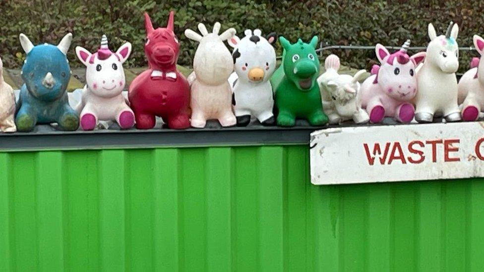 Inflatable toys on a skip at a recycling centre