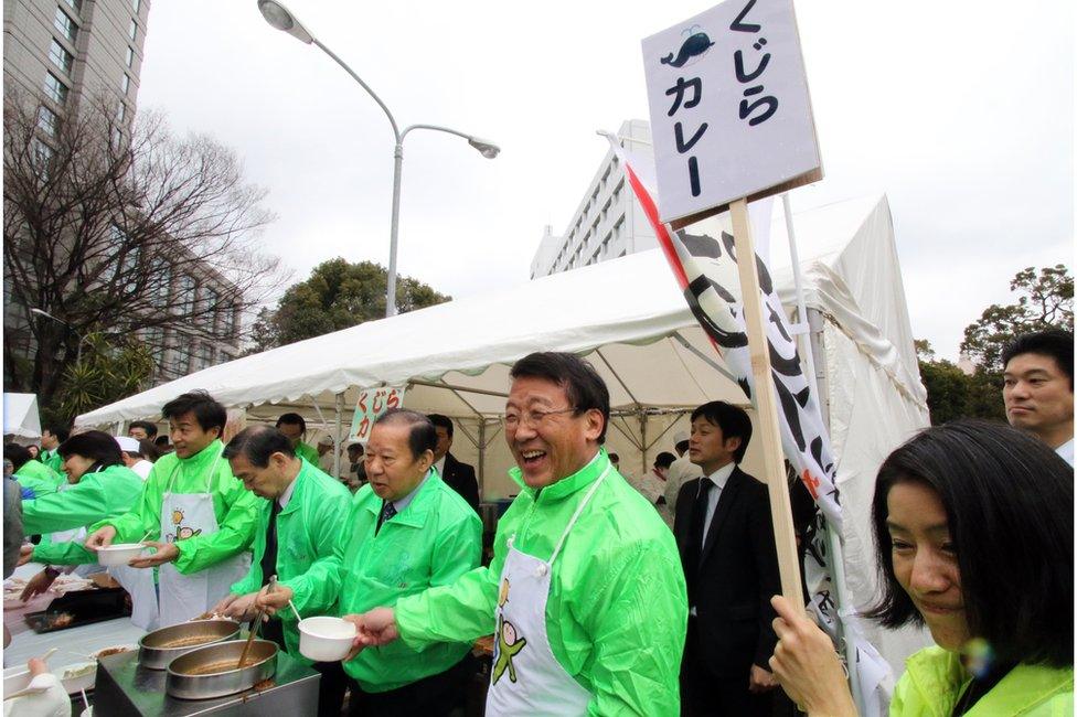 An outdoor food stall promoting whale curry