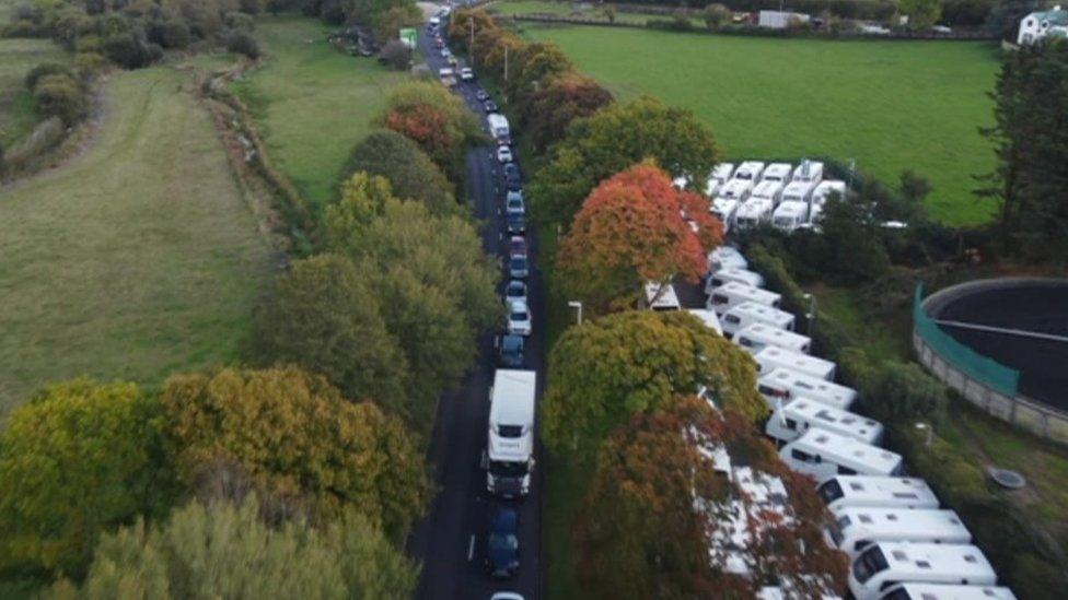 Aerial view of a long queue of traffic next to a caravan forecourt