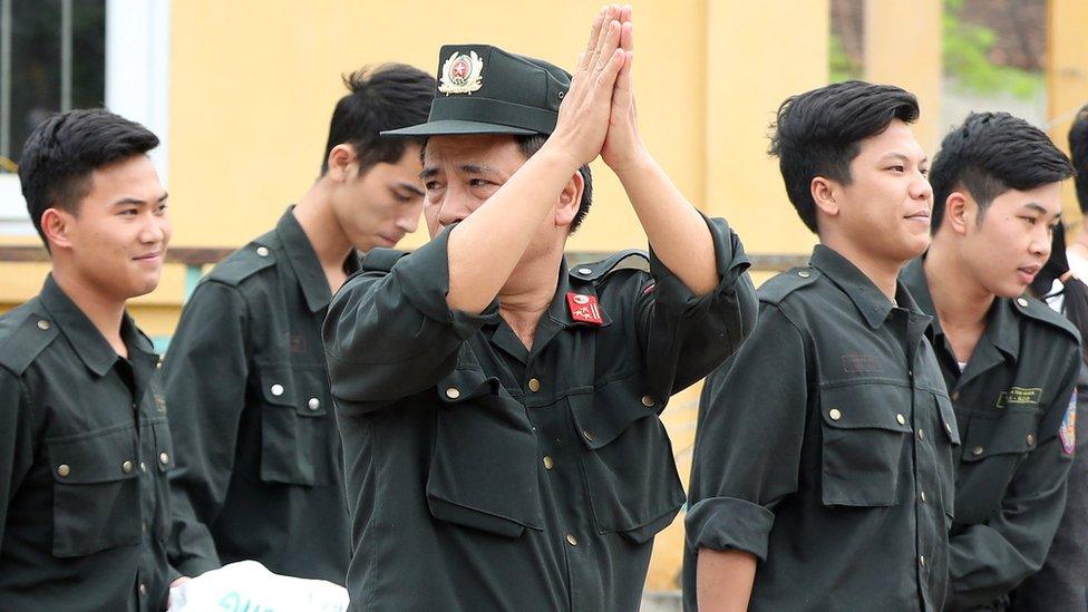 A police officer shows a gesture of thanks to local villagers as accompanies 19 former hostages, who were being held in a land dispute at the Dong Tam Commune on the outskirts of Hanoi, Vietnam, 22 April 2017