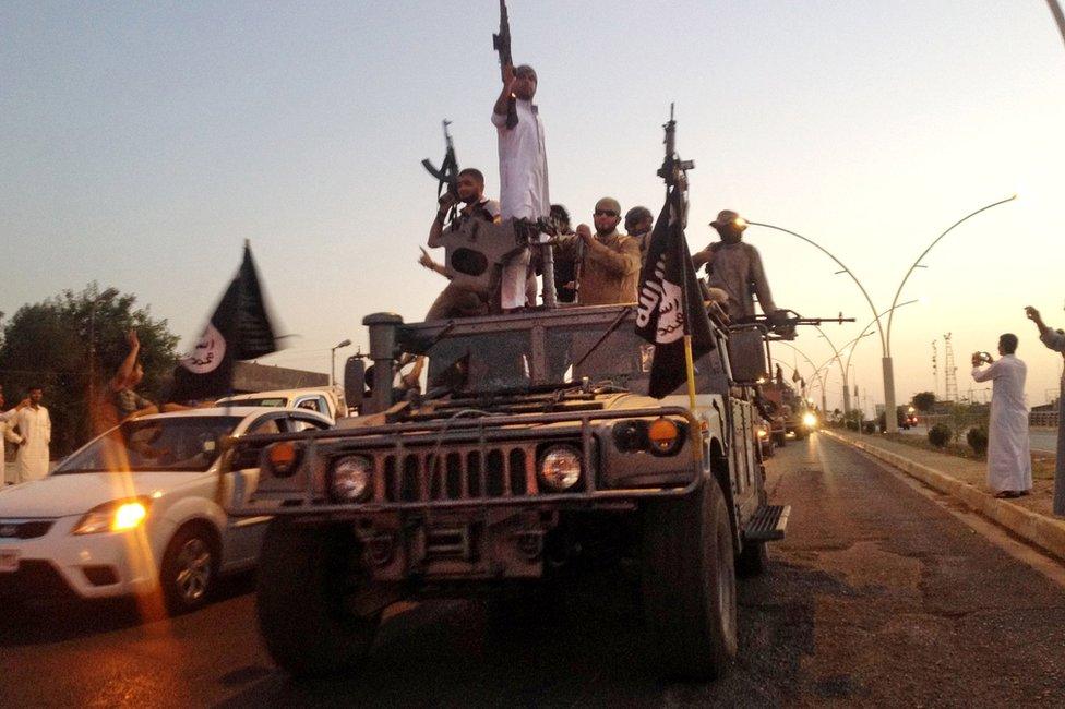 Islamic State in Iraq and the Levant (Isis) militants drive through Mosul in a captured Humvee (23 June 2014)